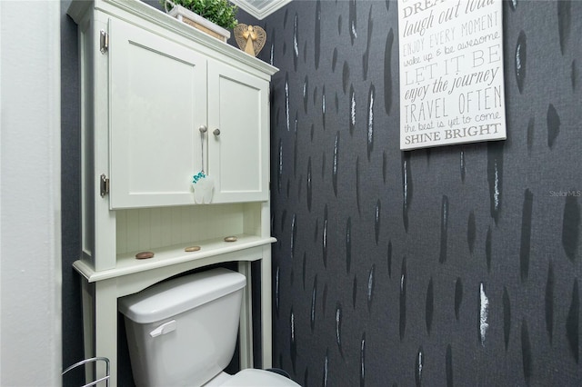 bathroom featuring toilet and crown molding