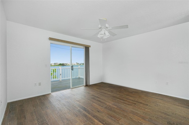 empty room with ceiling fan and dark wood-type flooring