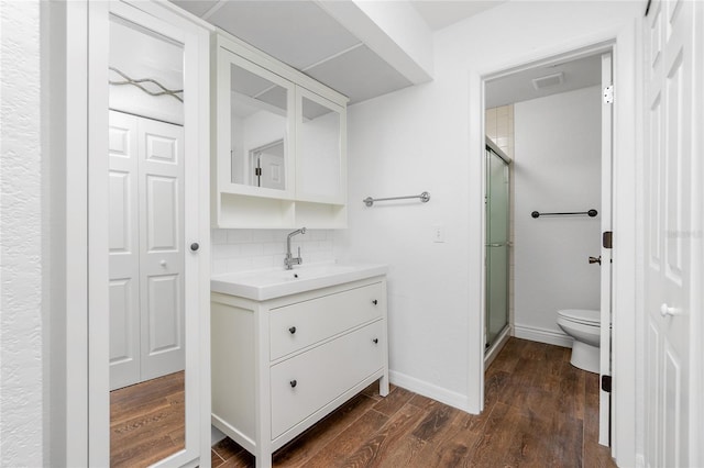 bathroom featuring wood-type flooring, vanity, tasteful backsplash, and walk in shower