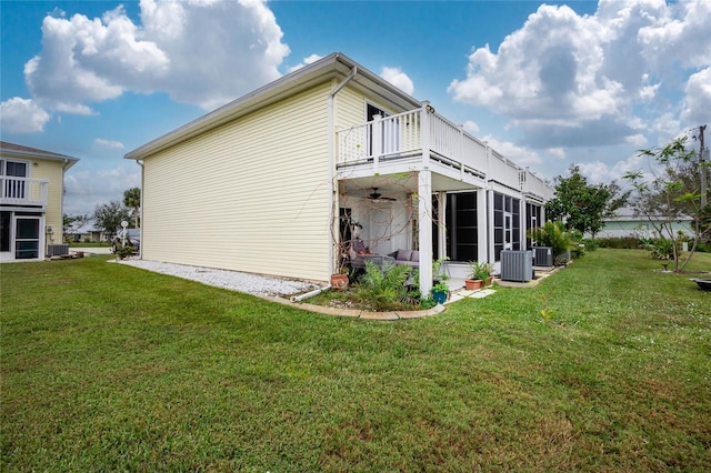 view of side of home with a yard, a balcony, and cooling unit