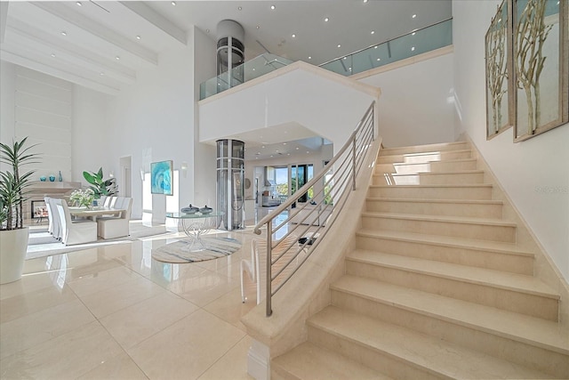 stairs with a towering ceiling and tile patterned flooring