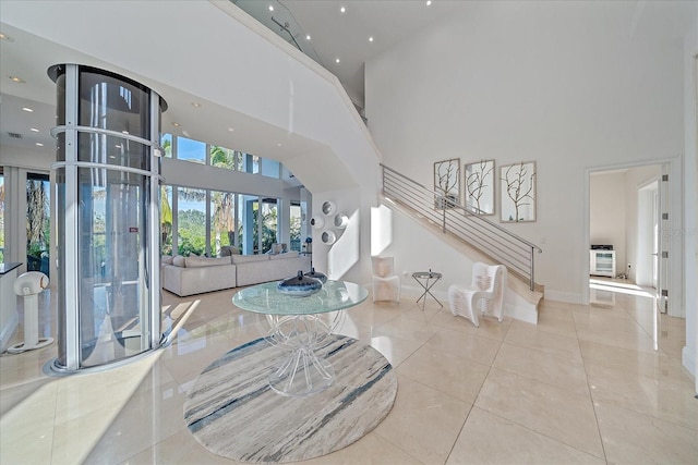 entryway with a high ceiling, heating unit, and light tile patterned floors