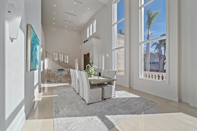 tiled dining space featuring a towering ceiling