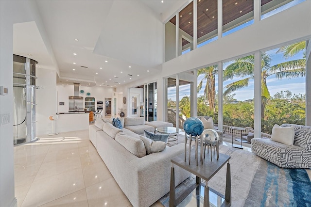 living room featuring a towering ceiling and light tile patterned flooring