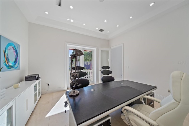 office area with a raised ceiling and light tile patterned floors