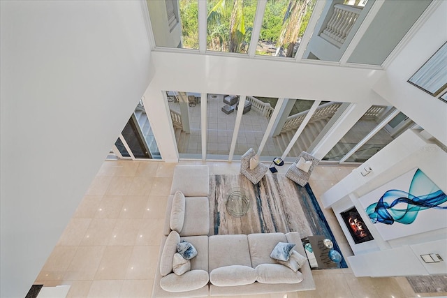 staircase featuring a high ceiling, a fireplace, and tile patterned floors