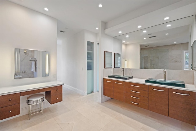 bathroom featuring a tile shower, vanity, and tile patterned flooring