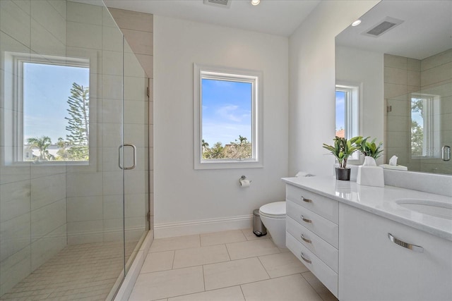 bathroom featuring toilet, vanity, tile patterned floors, and a shower with shower door