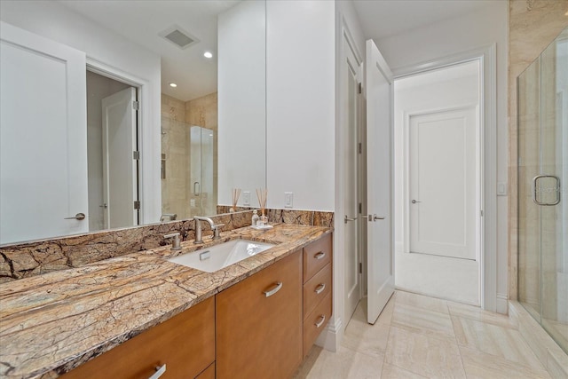 bathroom featuring vanity and a shower with shower door