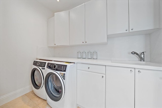 clothes washing area with washer and dryer, cabinets, light tile patterned floors, and sink