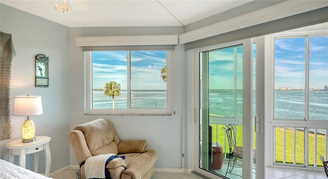 interior space with plenty of natural light, a water view, and light tile patterned floors