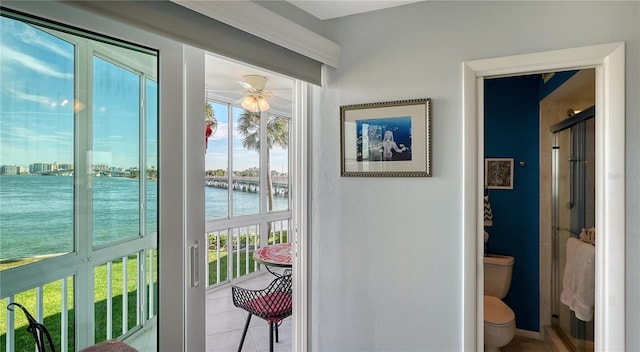 doorway to outside featuring ceiling fan, a water view, and light tile patterned floors