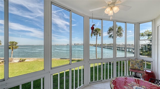 sunroom / solarium featuring a water view and ceiling fan