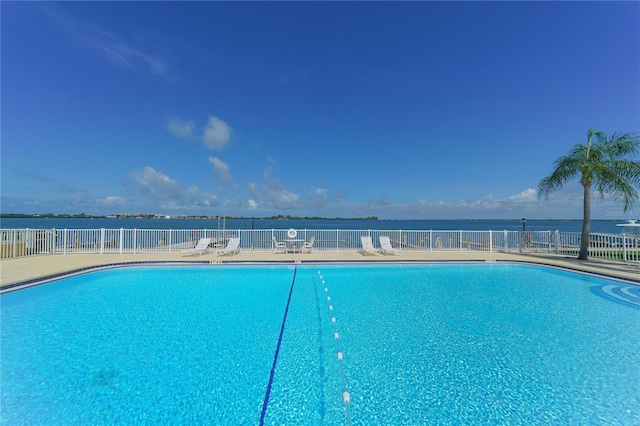 view of pool featuring a patio and a water view