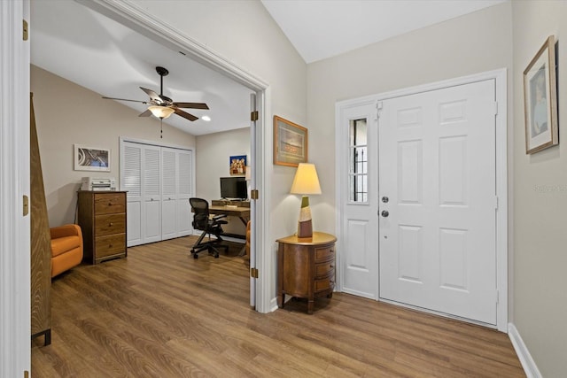 entryway with vaulted ceiling, wood finished floors, a ceiling fan, and baseboards