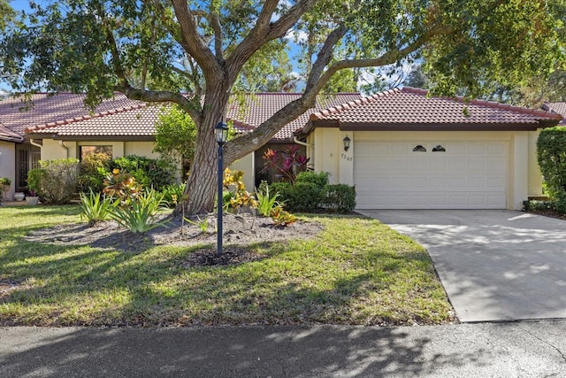 view of front of home with a garage, a tiled roof, driveway, and stucco siding