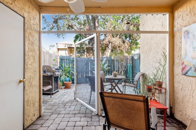 sunroom featuring ceiling fan