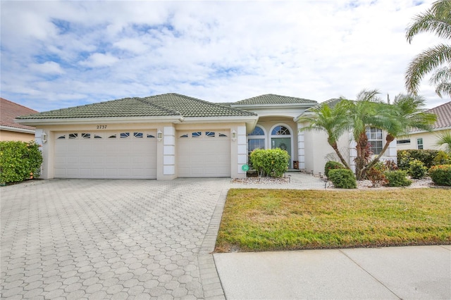 mediterranean / spanish-style house featuring a garage and a front yard