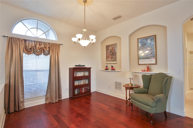 sitting room featuring lofted ceiling, hardwood / wood-style floors, and a chandelier