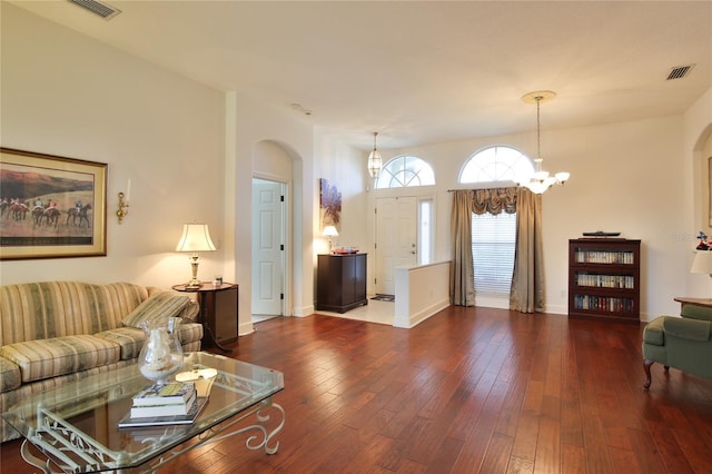 living room with a notable chandelier and dark hardwood / wood-style flooring