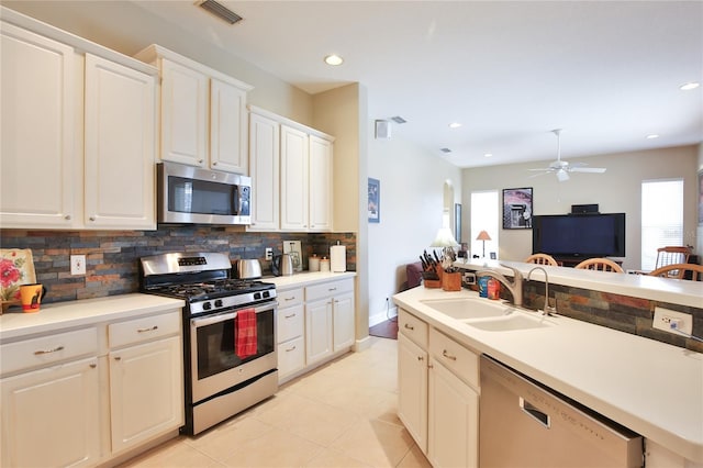 kitchen featuring sink, white cabinetry, appliances with stainless steel finishes, ceiling fan, and backsplash