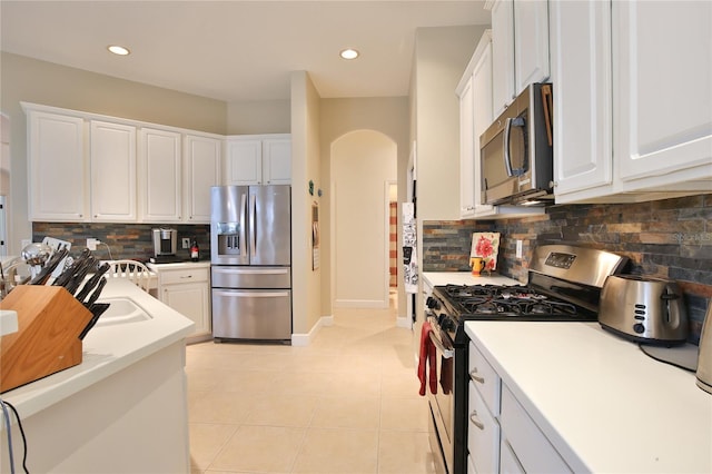 kitchen featuring white cabinetry, light tile patterned floors, tasteful backsplash, and stainless steel appliances