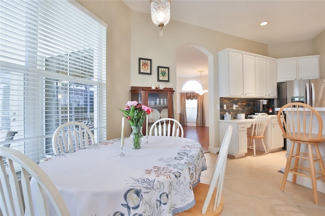 tiled dining space featuring an inviting chandelier