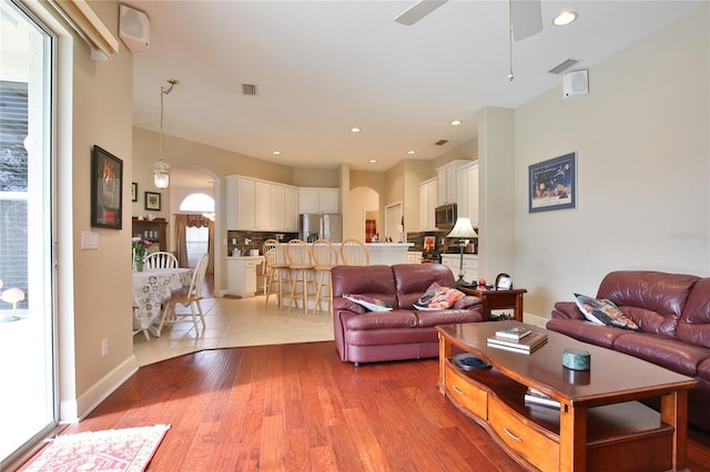 living room with light hardwood / wood-style floors and ceiling fan