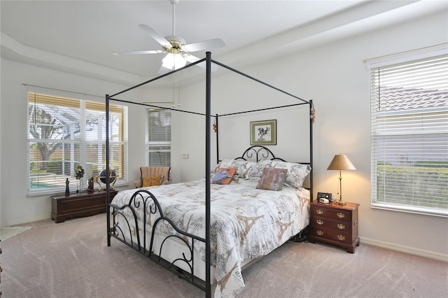 carpeted bedroom with multiple windows and ceiling fan