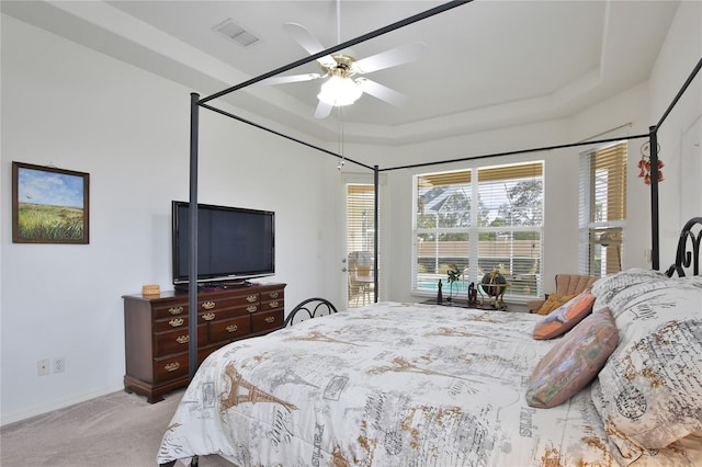 carpeted bedroom with access to exterior, a raised ceiling, and ceiling fan