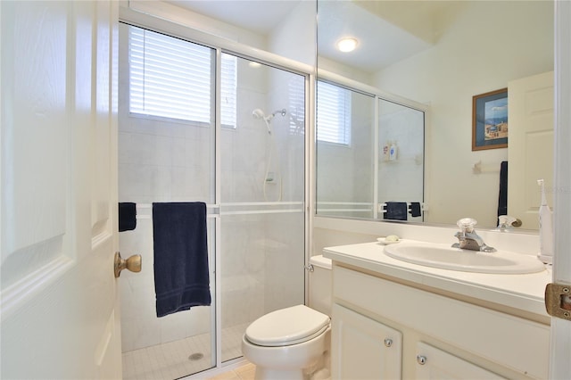 bathroom featuring vanity, plenty of natural light, a shower with door, and toilet