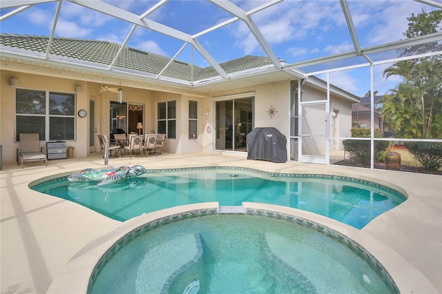 view of pool featuring a grill, a patio, ceiling fan, and glass enclosure