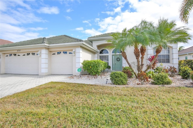 mediterranean / spanish-style home with a garage and a front yard