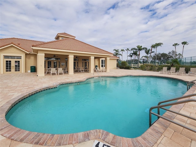 view of swimming pool featuring french doors, ceiling fan, and a patio area