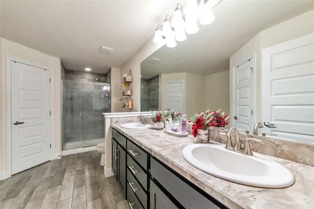 bathroom featuring vanity, hardwood / wood-style floors, an enclosed shower, and toilet