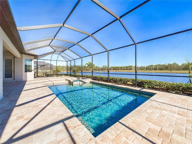 view of swimming pool featuring a water view, a patio area, and glass enclosure