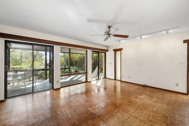 empty room featuring ceiling fan and track lighting