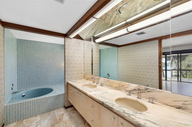 bathroom featuring beam ceiling, vanity, and a relaxing tiled tub