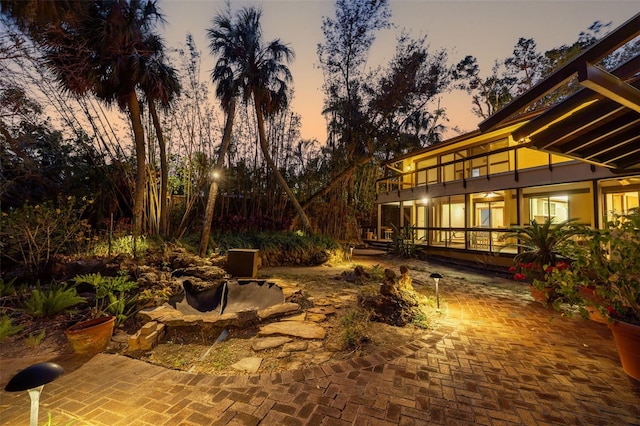 patio terrace at dusk featuring a balcony