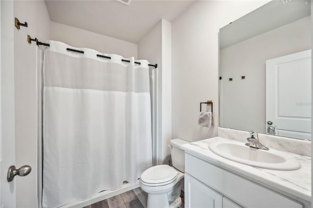 full bathroom featuring vanity, shower / tub combo, hardwood / wood-style flooring, and toilet