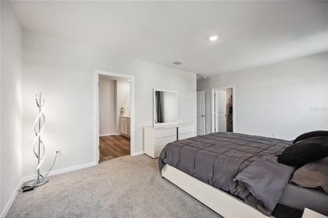 bedroom featuring ensuite bath and carpet floors