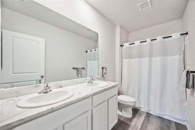 full bathroom with hardwood / wood-style flooring, vanity, toilet, and shower / bath combo with shower curtain