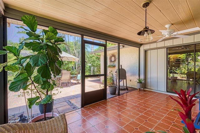 unfurnished sunroom with ceiling fan and wood ceiling