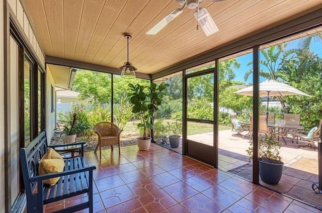 sunroom featuring ceiling fan, plenty of natural light, and wood ceiling