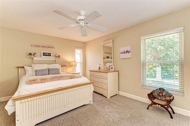 carpeted bedroom with multiple windows, a textured ceiling, and ceiling fan