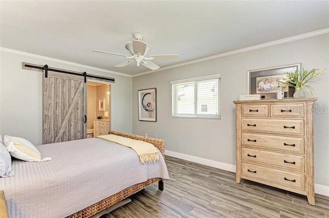 bedroom featuring hardwood / wood-style floors, a barn door, ceiling fan, and ornamental molding