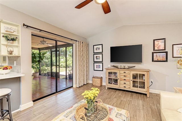 living room with light hardwood / wood-style floors and vaulted ceiling