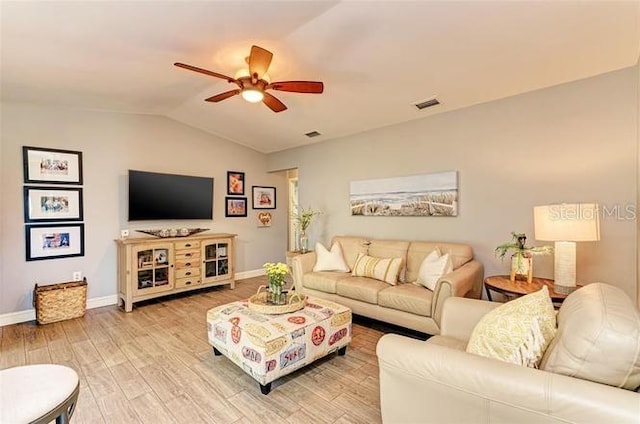 living room featuring light hardwood / wood-style floors, vaulted ceiling, and ceiling fan