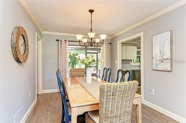 dining space featuring hardwood / wood-style floors, ornamental molding, and an inviting chandelier