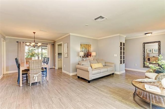 living room with a notable chandelier, wood-type flooring, and ornamental molding